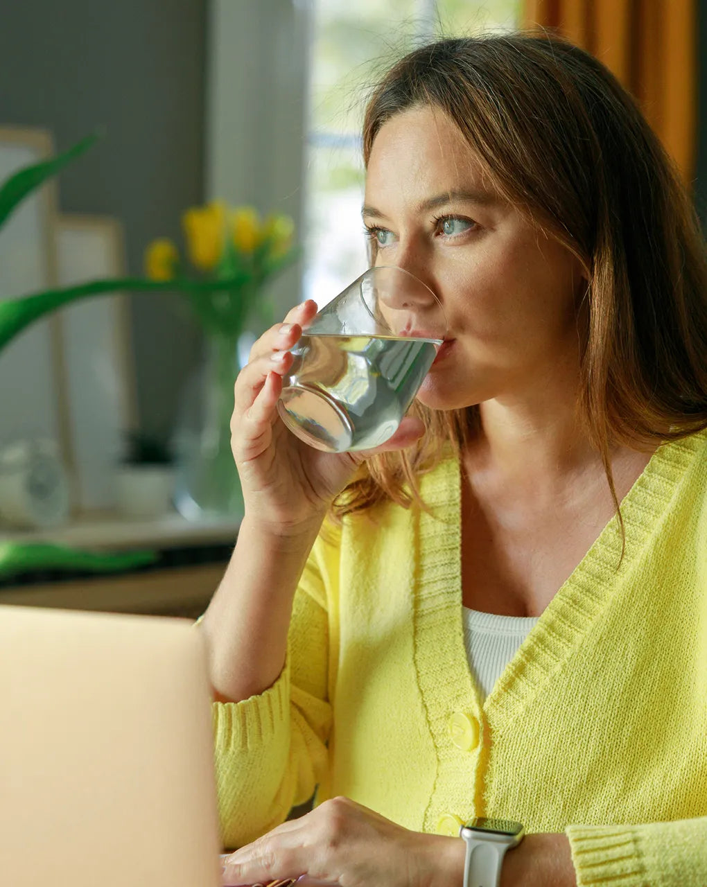 Frau trinkt ein Glas Wasser mit Geschmack