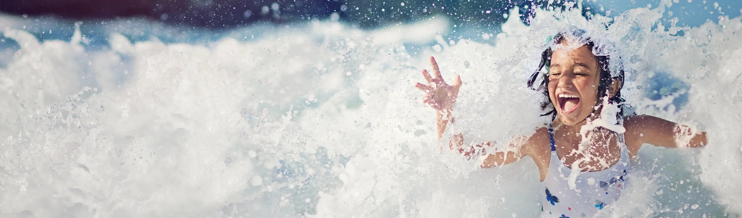 Kind im Wasser bei Wellen