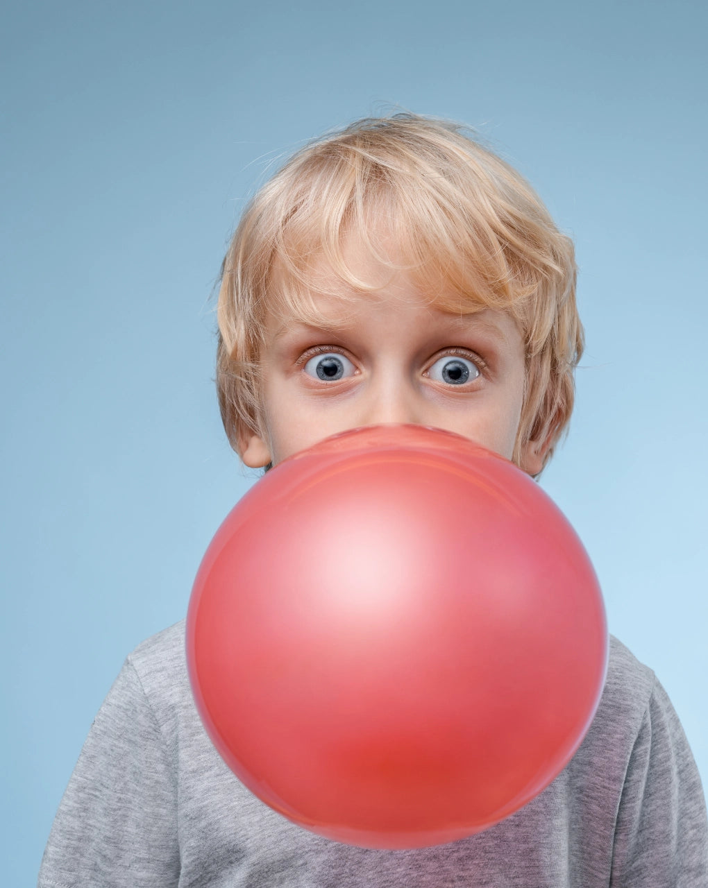 Child with large chewing gum bubble